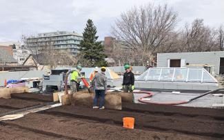 The system substrate was blown onto the roof in this way and distributed to create two identical plant beds - thanks to this separation using the formwork panels. © ZinCo Canada Substrate is blown onto the roof